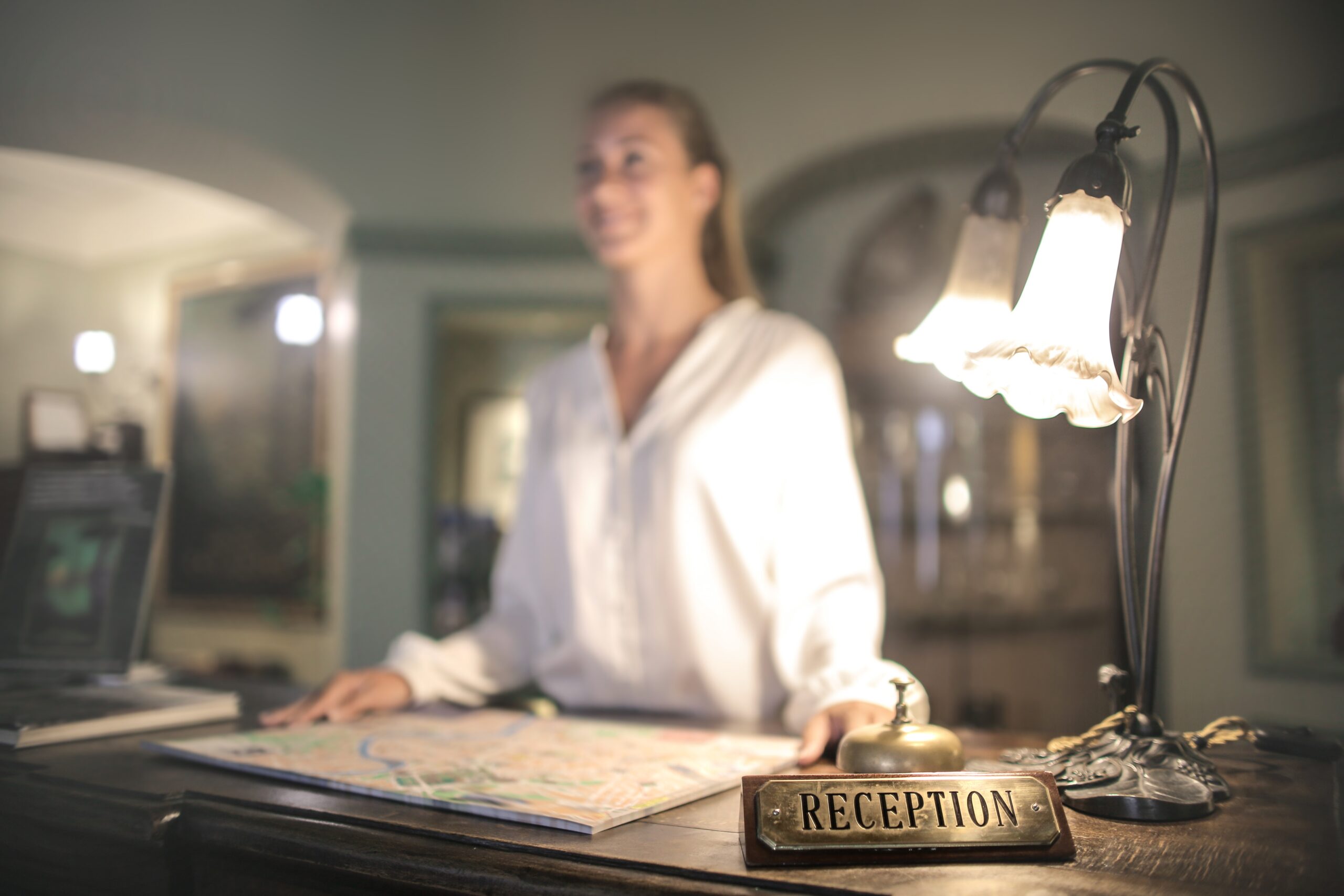 Hotel clerk greeting guest checking in at front desk