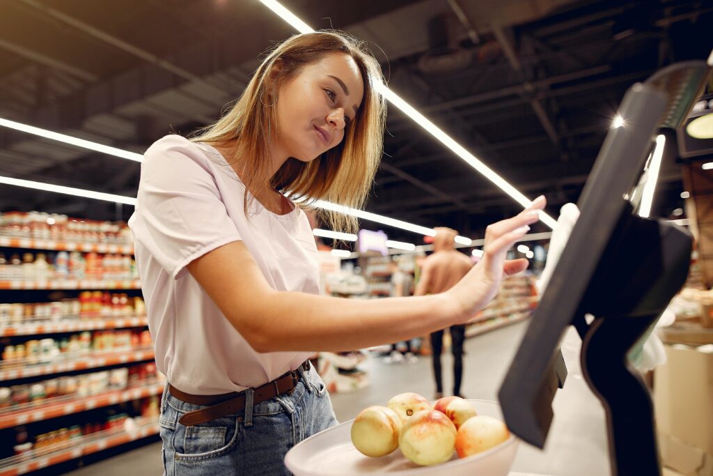 Woman using touch screen in grocery store